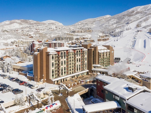 A premier ski resort nestled in snow-covered mountains, featuring slopeside lodging, base facilities, and direct access to groomed runs and lifts.