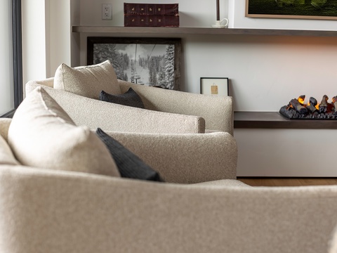 Sink into plush cushions and unwind by the glow of the fireplace, where warmth and modern elegance meet in this inviting living space.