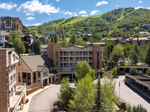 This mountain resort property sits nestled among lush green slopes, offering guests easy access to nearby outdoor activities and scenic alpine surroundings during the vibrant summer season.