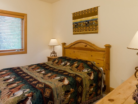 Unwind in your cozy bedroom with rustic wood furnishings, soft lighting, and southwestern charm. Natural light filters through the window, creating a peaceful retreat where you can recharge.