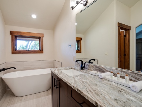 Unwind in your spa-like bathroom featuring a deep soaking tub, elegant marble countertops, and thoughtful touches that make relaxation effortless during your stay.