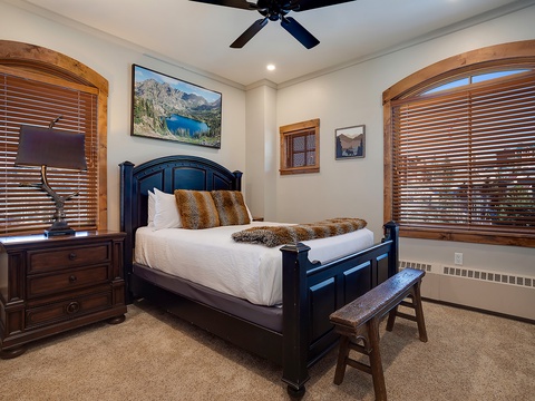 Your cozy bedroom awaits with a luxurious bed, warm wood accents, and serene mountain views to help you unwind after each day's adventures.