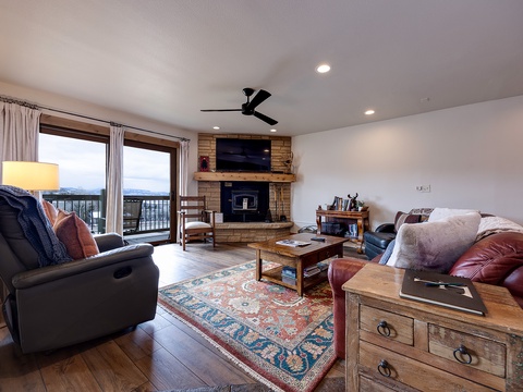 Unwind in your cozy living room, where plush seating, a warm fireplace, and sweeping mountain views create the perfect retreat after a day of adventure.