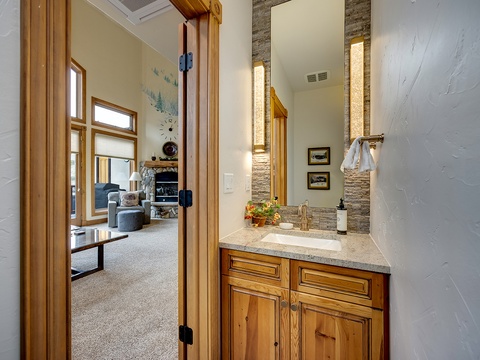 Refresh in your elegant private bathroom with granite counters, stone accent wall, and warm natural light highlighting thoughtful design details.