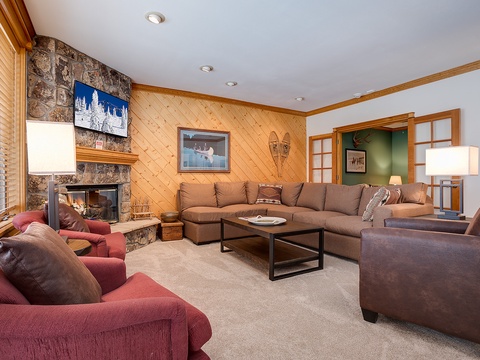 Gather around the stone fireplace in this inviting living room, where soft sectionals and leather seating create the perfect spot for your group to unwind after a day of mountain adventures.