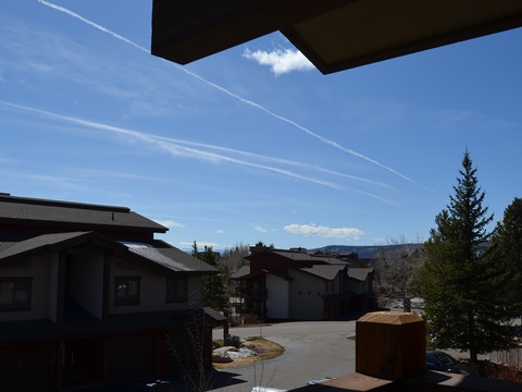 Mountain resort neighborhood with scenic views of distant peaks and evergreens, offering a peaceful setting for your vacation stay.