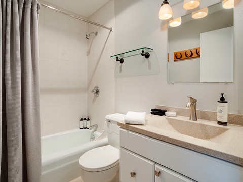 Refresh and unwind in your private bathroom, featuring a sleek tub-shower combo, modern vanity with generous counter space, and crisp linens ready for your arrival.