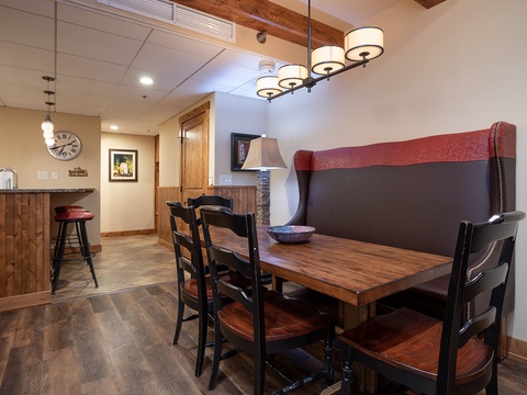 Gather around this inviting dining table for shared meals, with a stylish banquette and modern chandelier creating the perfect setting for your group's memorable moments together.