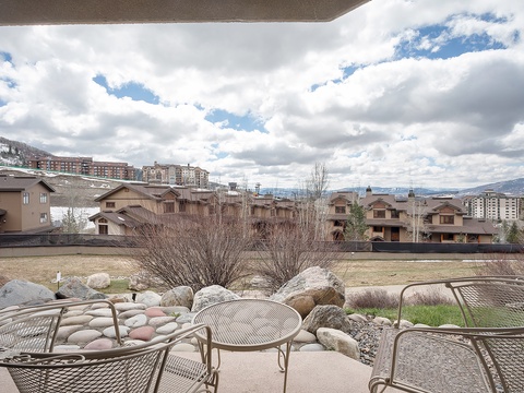 A private patio with comfortable seating overlooks a peaceful mountain community and distant peaks. Perfect for morning coffee or unwinding after a day of adventures.