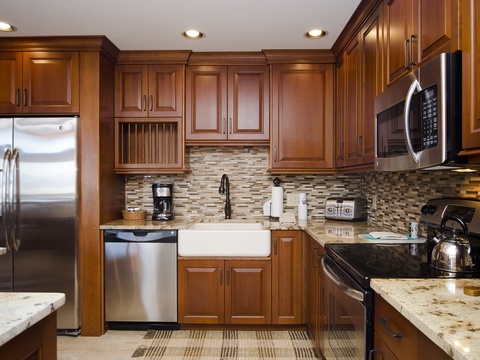 Your gourmet kitchen features stainless steel appliances, rich wood cabinetry, granite counters, and a stylish tile backsplash—perfect for preparing meals in style and comfort.