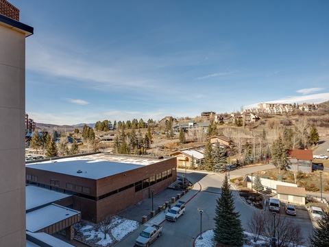 A scenic mountain community surrounded by evergreen forests and rolling hills, with the property nestled among residential neighborhoods and local amenities.