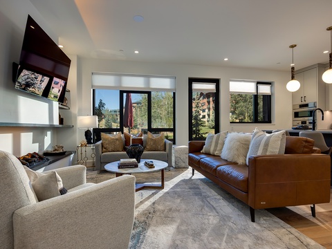 Sink into plush seating and feel the sunlight streaming through expansive windows as you take in mountain and forest views from your open, beautifully-designed living space.