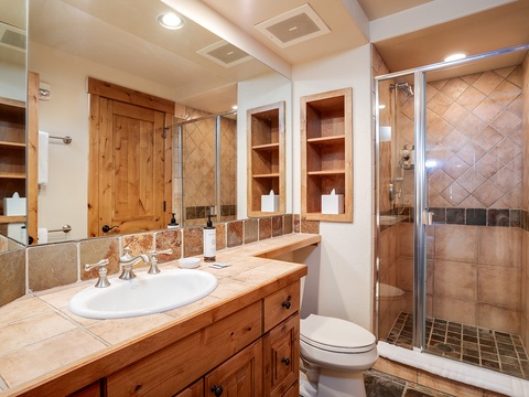 Step into your private retreat with warm wood tones, elegant tile work, and a spacious walk-in shower—everything you need to refresh and unwind in style.