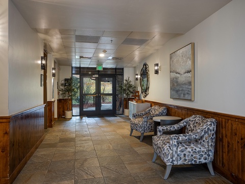 The property's welcoming entrance lobby features modern furnishings and natural light, with warm wood accents and tasteful artwork setting a comfortable tone for your mountain getaway.