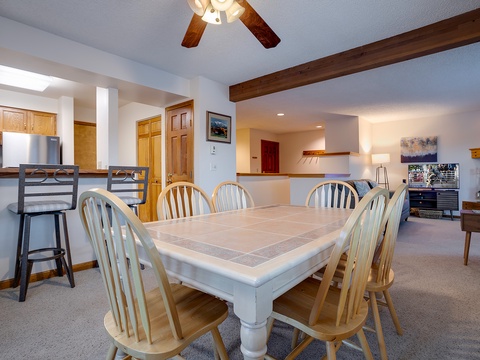 Gather around the spacious dining table, where rustic beams and warm lighting create the perfect ambiance for your group meals and lively conversations.