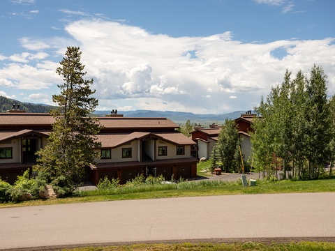 This mountain retreat sits in a peaceful setting surrounded by towering pines and aspens, with sweeping views of distant peaks and valley landscapes.
