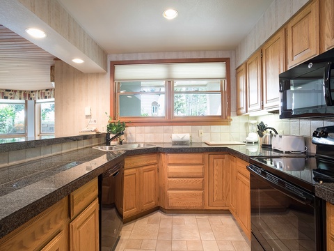 You'll find everything you need to whip up delicious meals in this fully equipped kitchen with modern appliances, ample counter space, and warm wooden cabinetry.