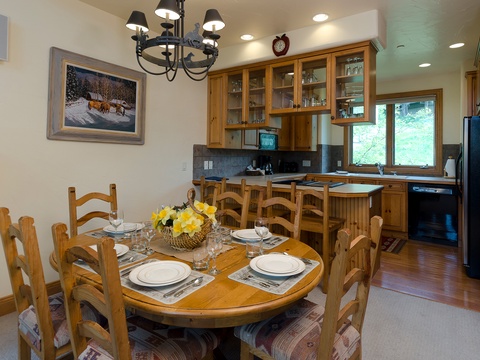 Gather around this inviting dining table where meals become memories, with a fully-equipped kitchen ready for your culinary adventures and warm wood tones throughout.