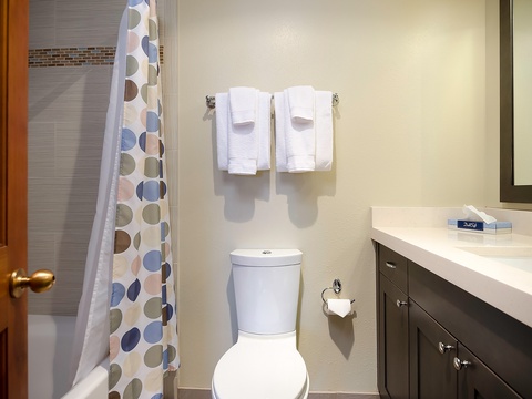 Your private bathroom features fresh towels, a modern vanity, and a tiled shower—everything you need to unwind after a day of exploring.