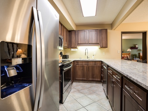Cook up your favorite meals in this fully equipped kitchen featuring stainless steel appliances, granite counters, and warm wood cabinetry—perfect for crafting memorable dishes during your stay.