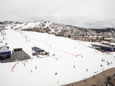 A winter mountain resort with ski slopes, chairlifts, and alpine village nestled against snow-covered peaks, offering access to outdoor recreation and mountain accommodations.