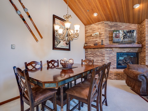 Gather around the table for meals with loved ones, warmed by the crackling fireplace beneath the vaulted wood ceiling—your cozy alpine retreat awaits.