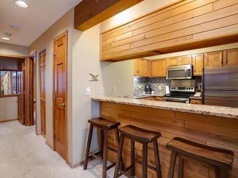 Gather at the breakfast bar in your fully equipped kitchen, where rich wood tones and granite counters create a warm mountain retreat feel. Everything you need for home-cooked meals is right at your fingertips.