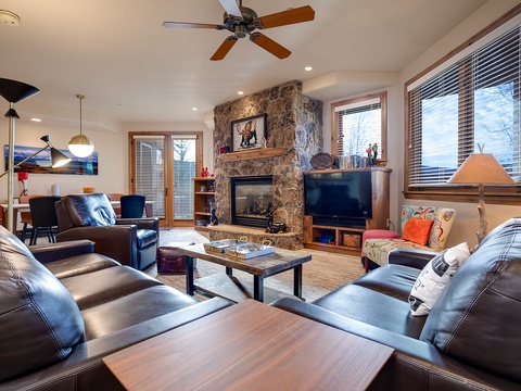 Sink into plush leather seating by the stone fireplace. Your mountain retreat blends warmth, natural light, and plenty of room to unwind after a day of adventure.