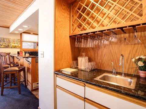 Your private wet bar features elegant wine glass storage, granite counters, and a polished sink—perfect for mixing drinks and entertaining in style.