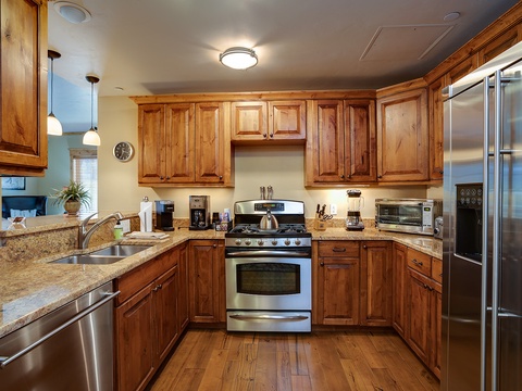 Your spacious kitchen features warm wood cabinetry, granite countertops, and stainless steel appliances—perfect for preparing delicious home-cooked meals during your stay.