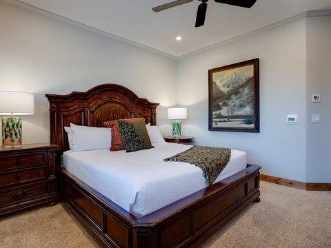 Sink into crisp white linens and plump pillows for a restful night's sleep in your inviting bedroom. The elegant wood furniture and peaceful mountain artwork create a serene retreat after your day of adventure.