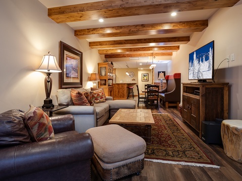 Unwind beneath warm, rustic beams in your inviting living space. Sink into plush seating and enjoy southwestern charm, with rich wood accents and thoughtful touches throughout.