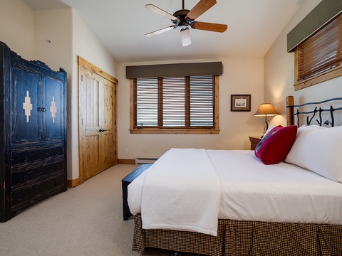 Unwind in this cozy bedroom with plush bedding, rustic accents, and a ceiling fan to keep you comfortable year-round.