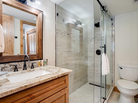 Your private bathroom features a walk-in shower with elegant tile work, granite countertops, and fresh towels—everything you need to start your day feeling refreshed and ready for adventure.