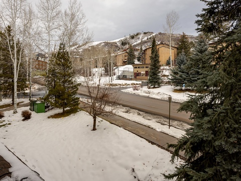 A picturesque ski village setting with snow-dusted slopes and evergreens framing the surrounding mountain resort community. The property offers convenient access to winter recreation in a tranquil alpine neighborhood.