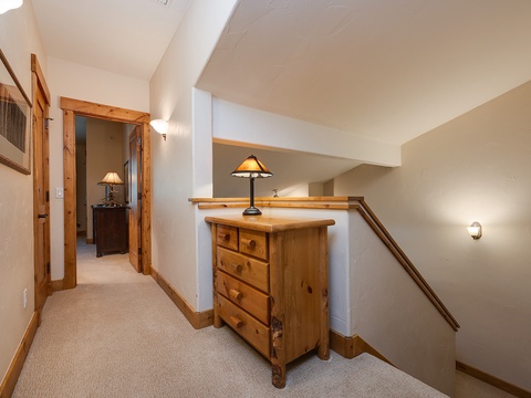 Your upstairs hallway blends rustic charm with modern comfort. Vaulted ceilings create an airy, open feel while warm wood accents and soft lighting make you feel right at home.