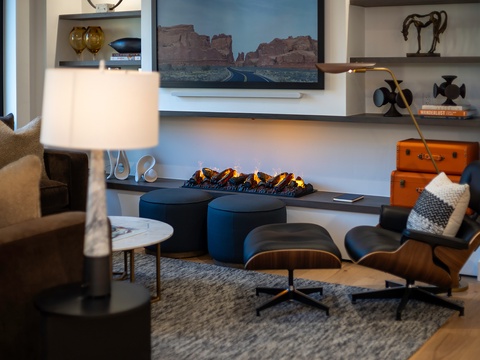 Sink into the cozy lounge chair by the flickering fireplace and let your worries melt away—this is your space to unwind in style and comfort.