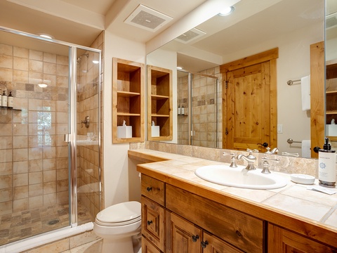 Step into your private spa-like retreat, where warm wood finishes and natural stone welcome you. Refresh in the spacious walk-in shower or unwind at your elegant vanity—your perfect mountain escape.
