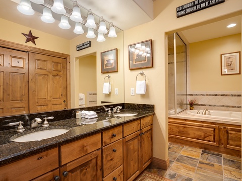 Unwind in your spacious bathroom with dual vanities, a soaking tub, and a separate glass-enclosed shower—your personal retreat after a day of mountain adventures.