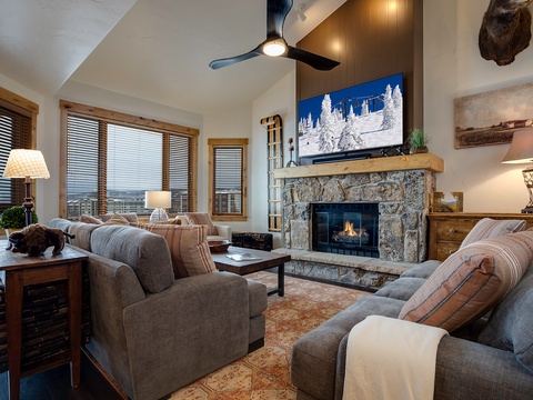 Unwind in your cozy living room with plush seating, a warm fireplace, and mountain views. Vaulted ceilings and rustic décor create a welcoming retreat after a day on the slopes.