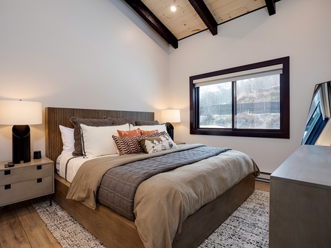 Drift into restful sleep beneath stunning exposed beams, surrounded by warm textures and soft lighting that make this cozy retreat feel like home.