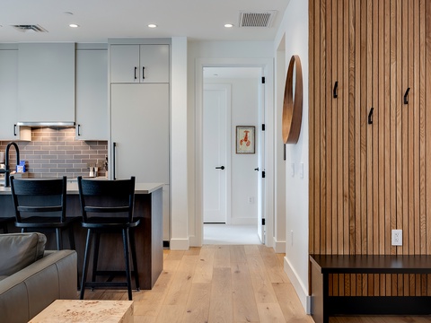 Gather around your sleek kitchen island with modern bar seating, perfect for morning coffee or casual meals while enjoying the open-concept design and warm wood accents throughout your space.