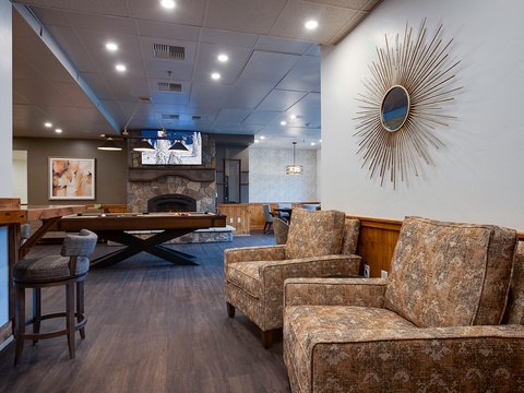 Unwind in this inviting lounge with plush seating, a cozy fireplace, and entertainment options—your perfect spot to relax after exploring.