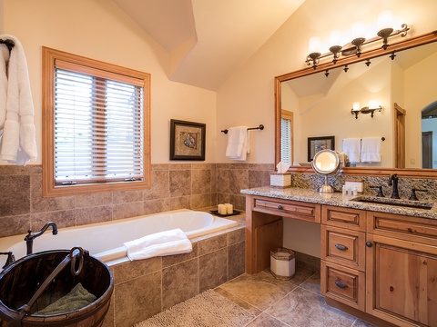 Step into your luxurious ensuite retreat—warm natural tones wrap around a deep soaking tub, dual vanities, and soft towels at the ready for pure relaxation.