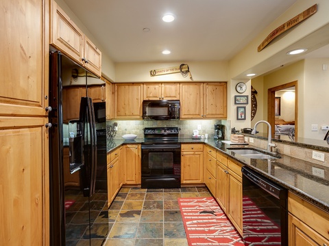 Your fully equipped kitchen with granite counters, modern appliances, and warm knotty pine cabinetry invites you to prepare fresh meals during your mountain getaway.