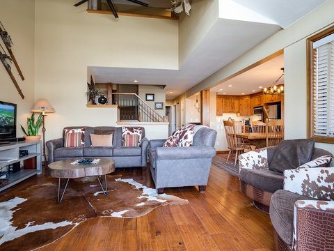 Unwind in your spacious living area with high vaulted ceilings, plush seating, and warm wood floors. The open layout flows seamlessly into a fully-equipped kitchen, perfect for gathering after mountain adventures.