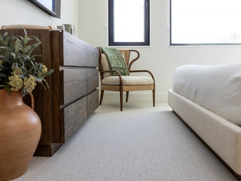 Curl up in your cozy reading nook where natural light pours through bright windows, a plush chair invites relaxation, and rustic wooden touches create that warm, home-away-from-home feeling.