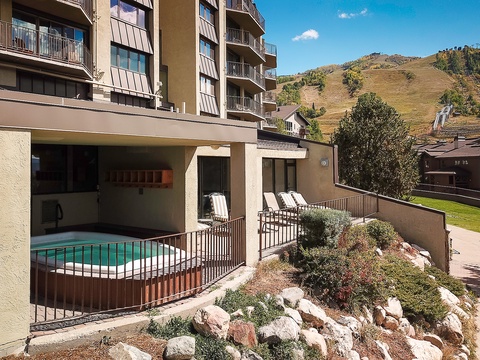 The property features a semi-covered pool and lounge area with mountain views, surrounded by natural landscaping in a residential resort setting.