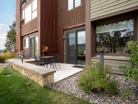Modern multi-level property featuring warm wood and earth-tone siding, nestled in a scenic mountain setting with landscaped grounds.