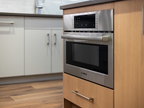 Your sleek, modern kitchen features a built-in Bosch microwave and oven, ready for easy meal prep. Clean lines and quality appliances make cooking effortless.
